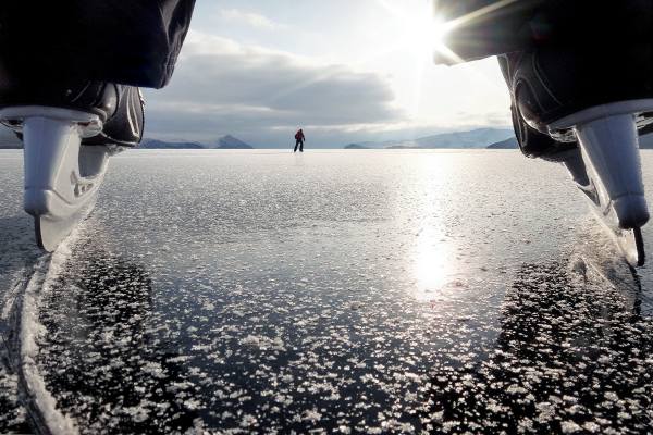 на Байкале в коньках по льду зимой